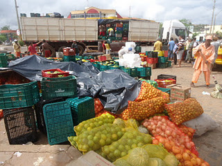 Caminhão carregado com frutas e verduras perdeu parte de sua carga ao realizar a curva de acesso à rotatória
