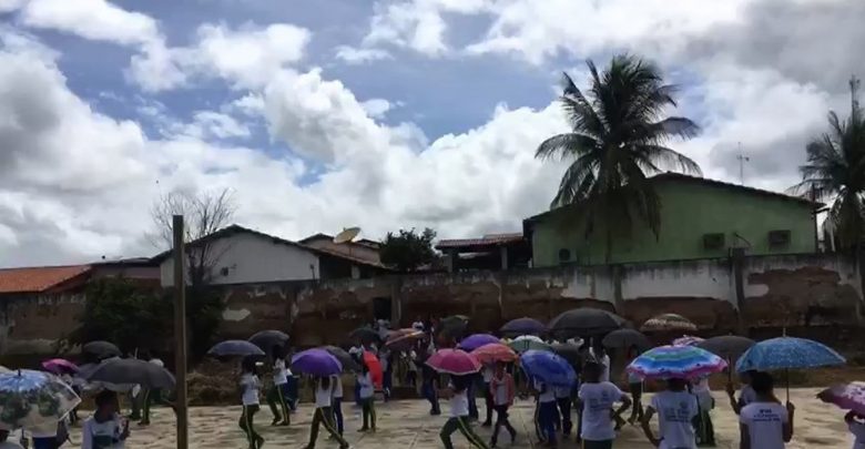 Alunos protestam com guarda-chuva falta de cobertura de quadra — Foto: Reprodução/Redes Sociais