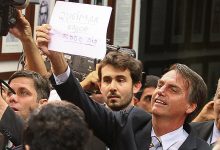 Deputado Jair Bolsonaro (PP-RJ) mostra cartaz com a frase "queimar a rosca todo dia" para os manifestrantes contrários ao presidente da Comissão dos Direitos Humanos, o deputado e pastor Marco Leia maisFeliciano (PSC-SP)