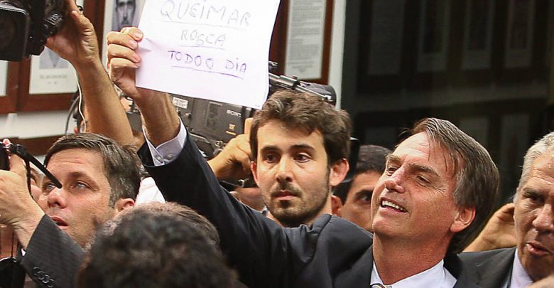 Deputado Jair Bolsonaro (PP-RJ) mostra cartaz com a frase "queimar a rosca todo dia" para os manifestrantes contrários ao presidente da Comissão dos Direitos Humanos, o deputado e pastor Marco Leia maisFeliciano (PSC-SP)
