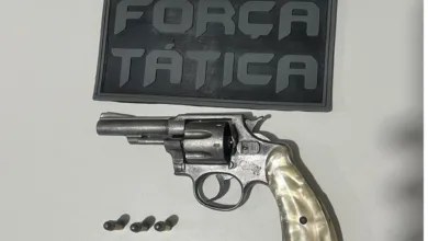 Arma em cima da mesa com escudo da Força Tática da Polícia Militar do Piauí